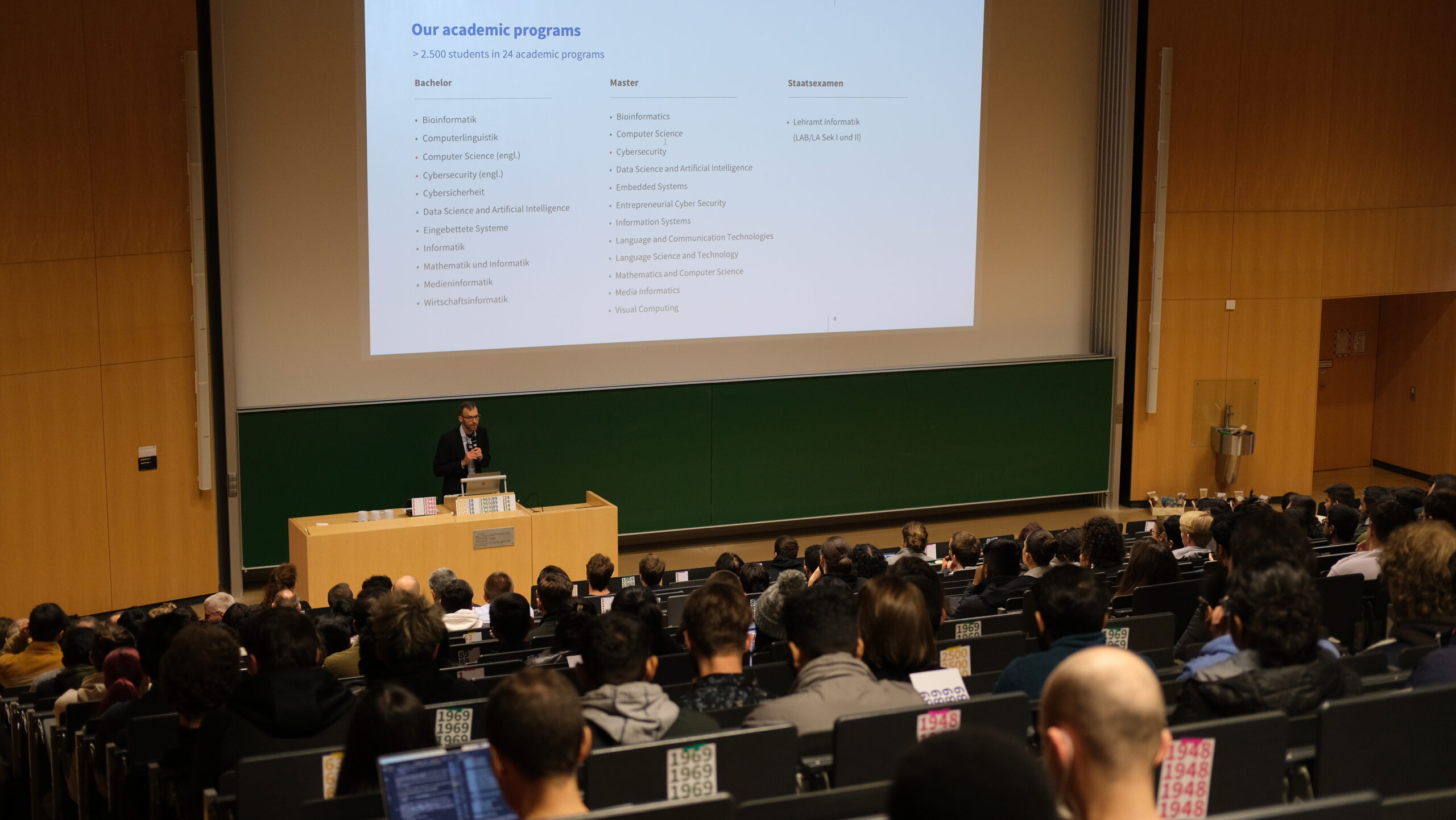 Semesterinfos_2048x580px Bild von Studierenden in Hörsaal mit Überschrift "See you online!"