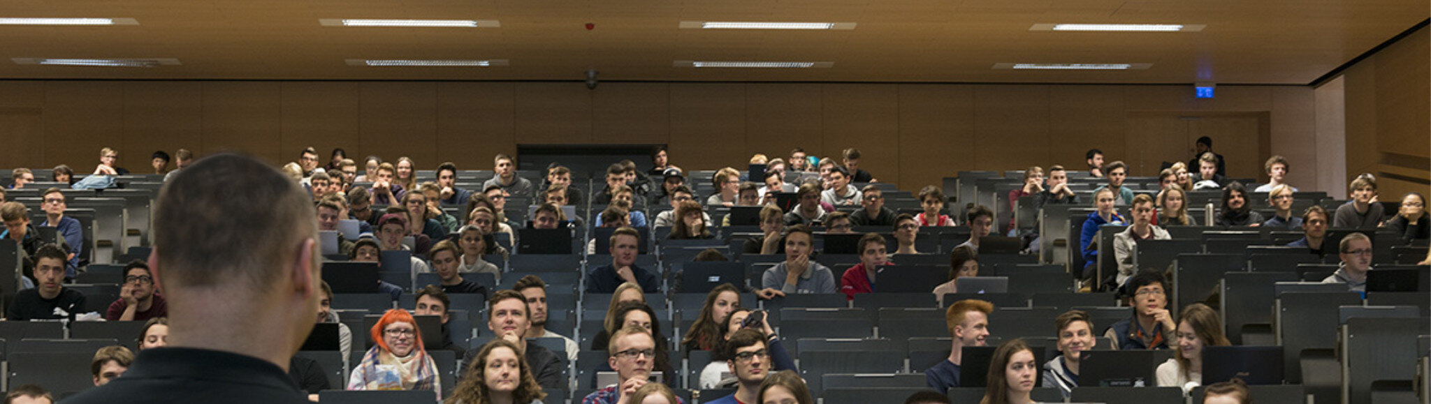 Bild von Studierenden in Hörsaal mit Überschrift "See you online!"